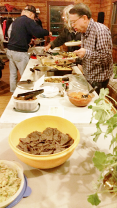 One of the three long food tables at the November potluck dinner sponsored by Rochester Area Vegan Society. On the menu, among other things, were fresh salads including a kale salad tossed with a light peanut dressing and a wild rice salad filled with veggies, a vegan version of red beans and rice, California coleslaw and mac and “cheese” made with pureed squash. 