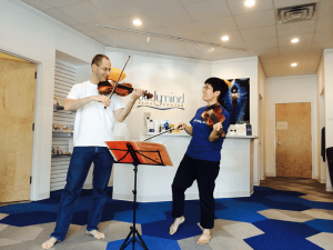 David Brinkman, founder and owner of Bodymind Float Center, and his, Pattie Sunwoo, paying violin at the float center.