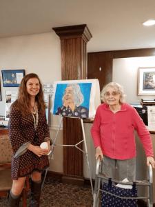 Students from Honeoye Central School next to residents at Quail Summit in Canandaigua whose portraits they painted as part of the school project. 